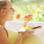 Femme enceinte qui mange un fruit