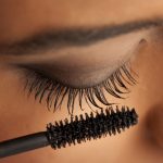femme qui met du mascara recourbant
