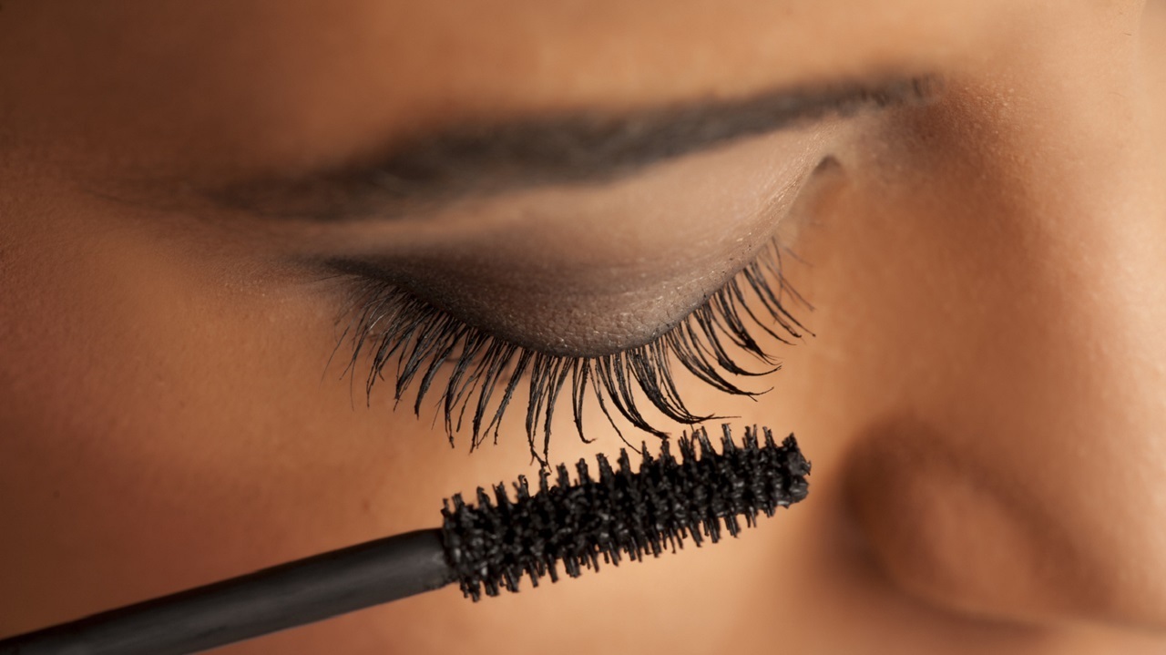 femme qui met du mascara recourbant