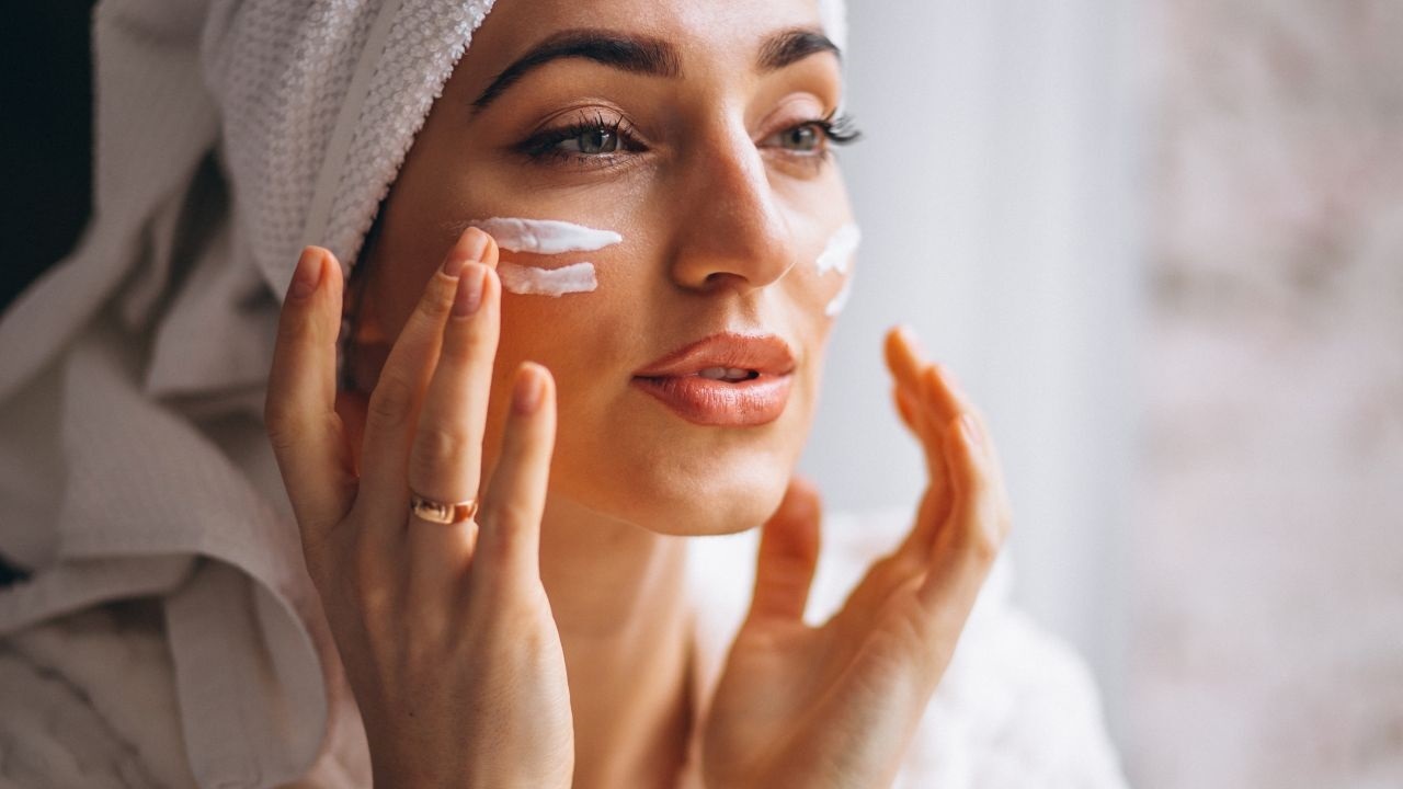 Femme qui se met de la crème sur le visage