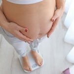 Femme enceinte sur une balance