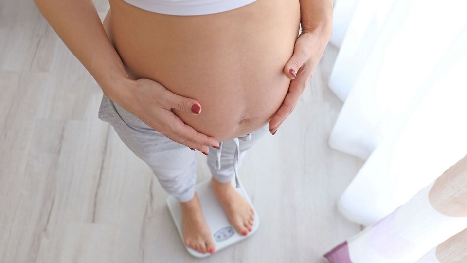 Femme enceinte sur une balance