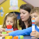 Assistante maternelle en compagnie de deux enfants