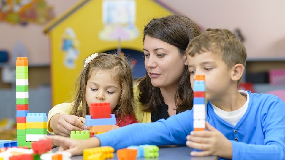 Assistante maternelle en compagnie de deux enfants