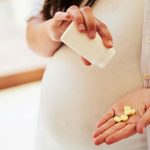 Femme enceinte qui prend des vitamines