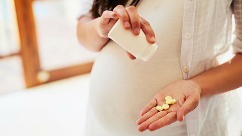 Femme enceinte qui prend des vitamines